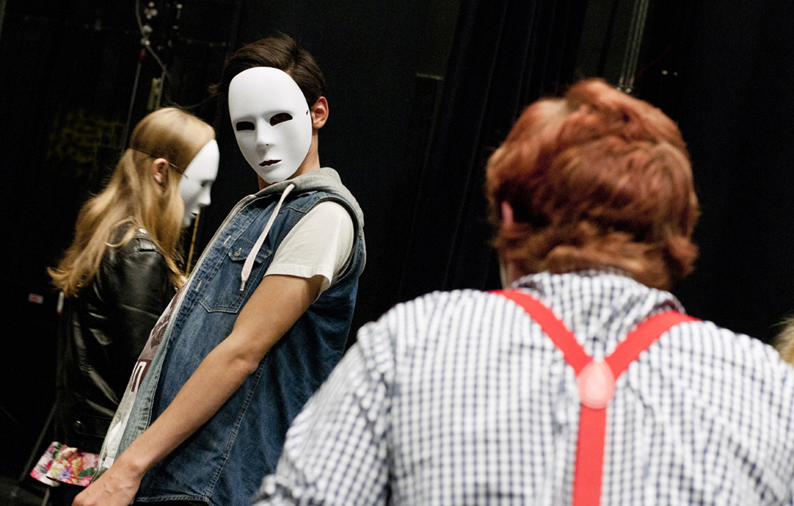 Bild som visar elever som som får regi, eleverna har vita masker.